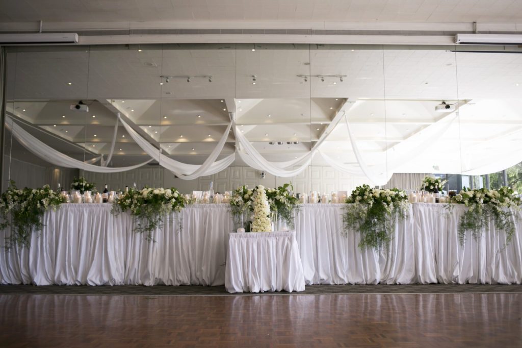 Wedding head table white roses - See all the beautiful details on B. Lovely Events! #wedding #realwedding #weddingideas #weddingtips #weddingdecorations
